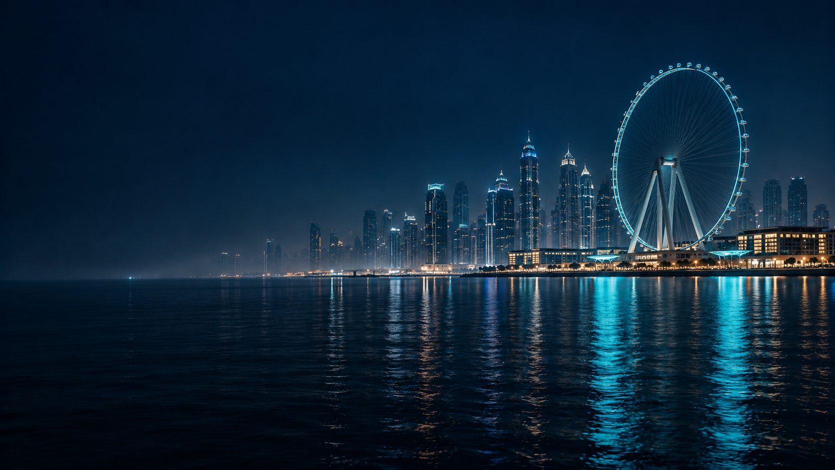 Ain Dubai and the Dubai Marina skyline at night, lights reflected in the water
